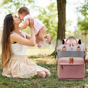 Bolso rosa acompañando a mamá con bebé.